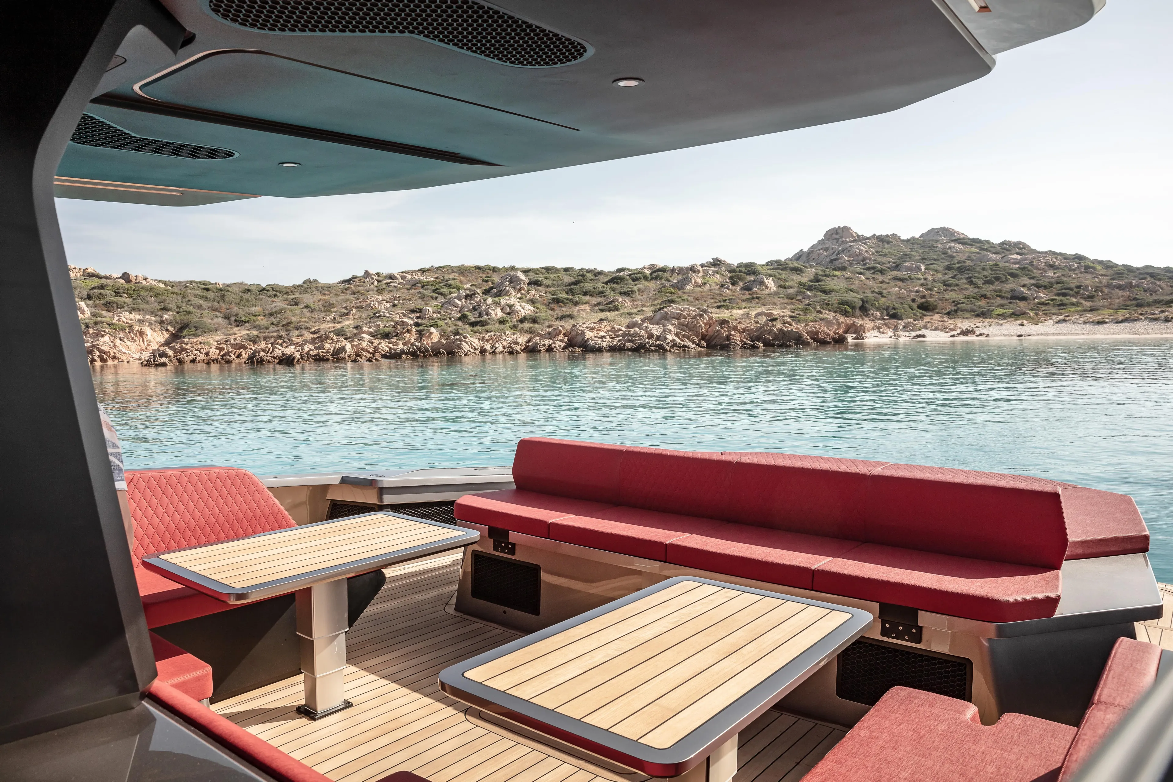 Maori 64 Yacht Photos Pics Luxurious Maori M64 yacht interior with red seating, wooden tables, and scenic coastal view, 2025 model.