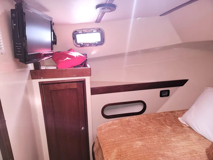 Hardtimes Yacht Photos Pics Interior cabin of 2009 Northern Bay 38 Sportfish with bed, TV, and storage.