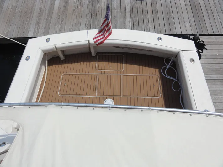  Yacht Photos Pics 1990 Viking 45 Convertible boat deck with American flag and wooden flooring.