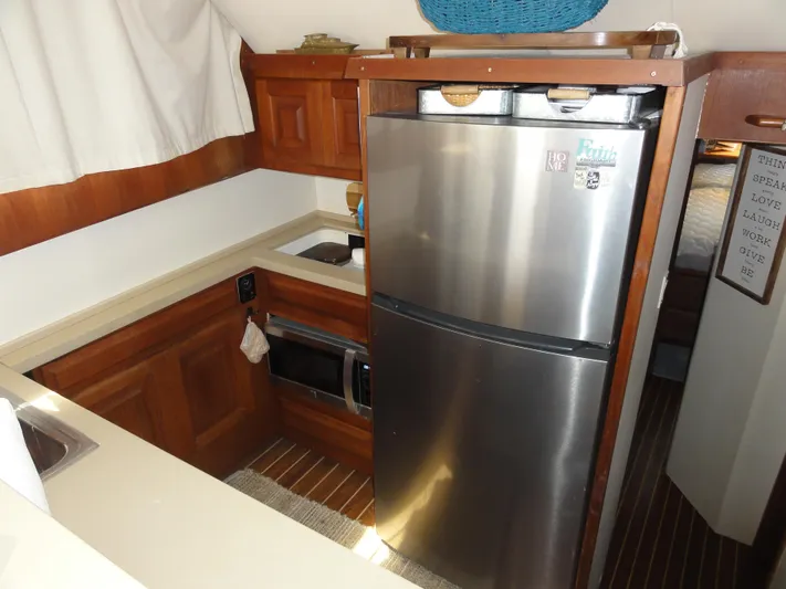  Yacht Photos Pics 1990 Viking 45 Convertible yacht kitchen with stainless steel fridge and wooden cabinetry.