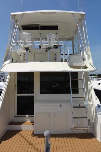 Yacht Photos Pics 1990 Viking 45 Convertible yacht with upper deck seating and ladder, docked under clear skies.