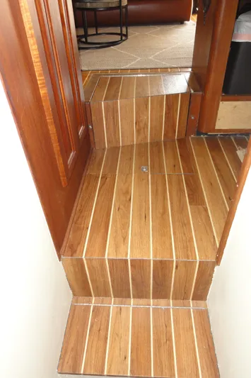  Yacht Photos Pics Wooden steps inside a 1990 Viking 45 Convertible yacht, leading to a carpeted area.