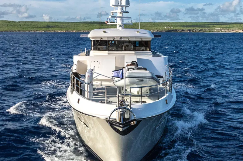 Martini Yacht Photos Pics Nordhavn N63 yacht cruising on open sea, 2022 model, with scenic coastline backdrop.