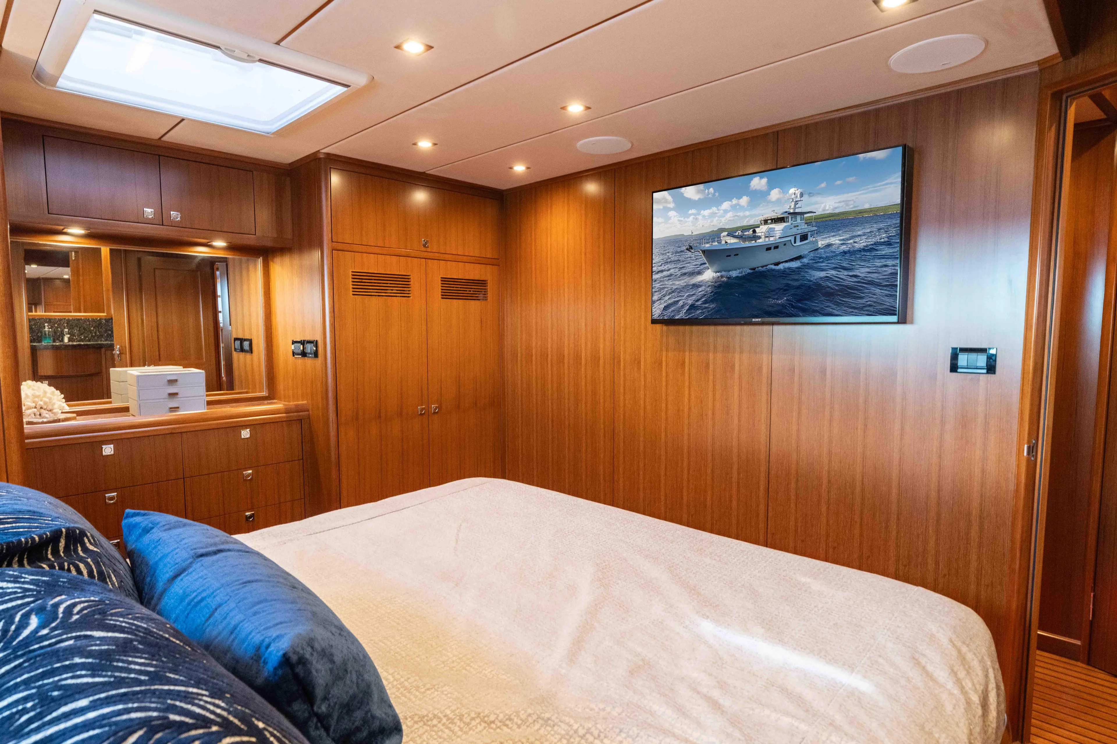 Martini Yacht Photos Pics Luxurious Nordhavn N63 2022 yacht bedroom with wood paneling and wall-mounted TV.