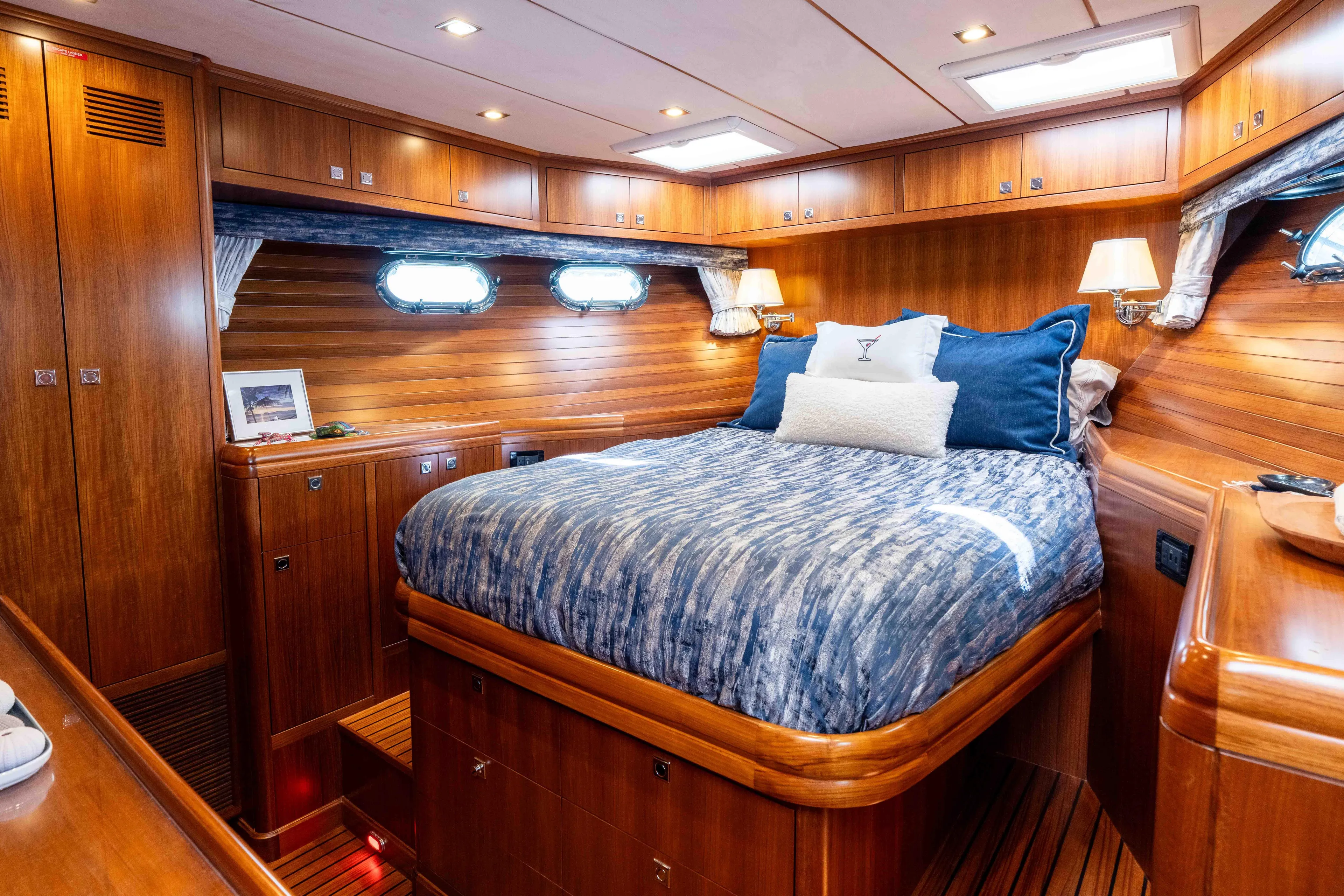 Martini Yacht Photos Pics Luxurious 2022 Nordhavn N63 yacht cabin with wood paneling and cozy bedding.