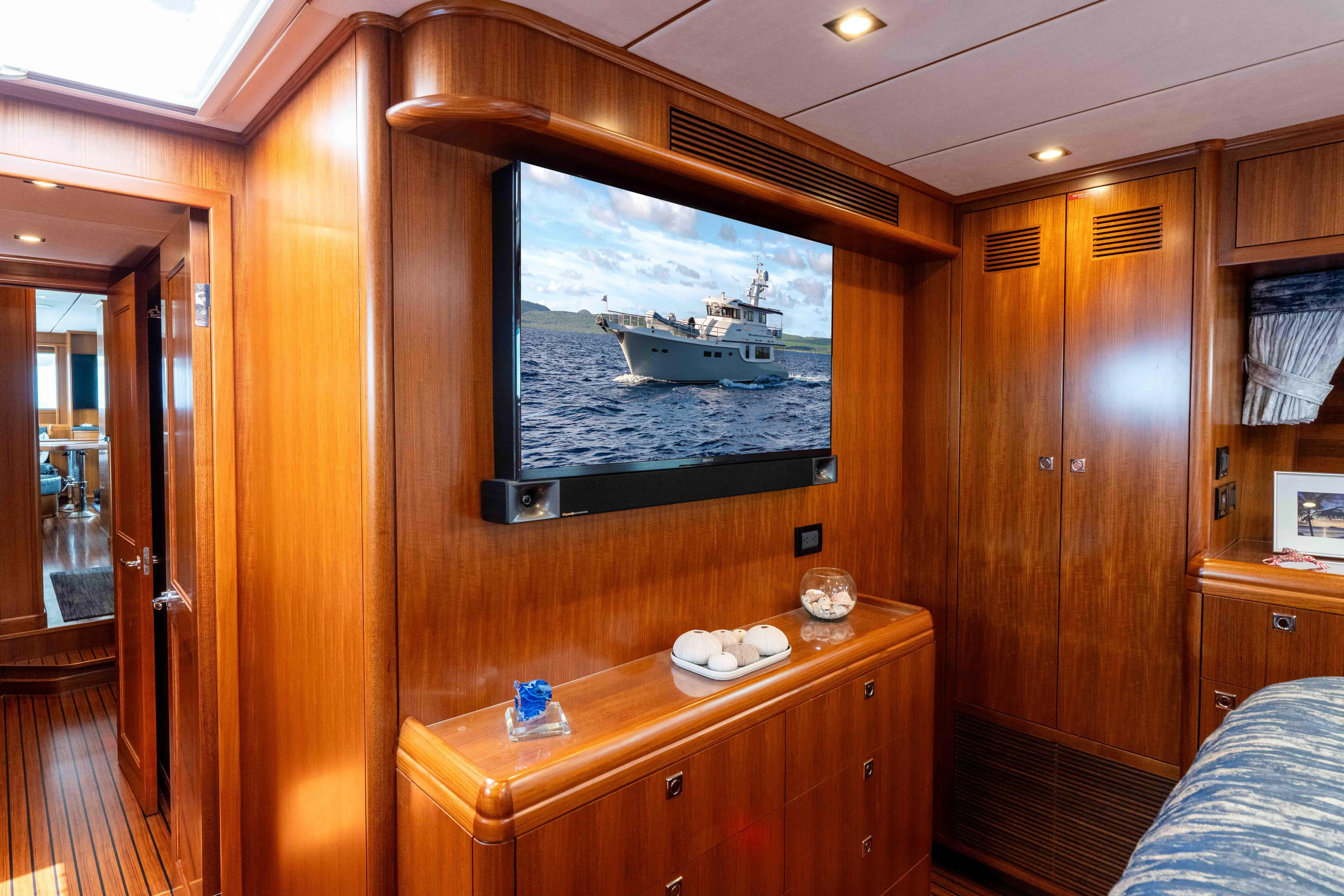 Martini Yacht Photos Pics Luxurious 2022 Nordhavn N63 yacht interior with wood paneling and mounted TV.
