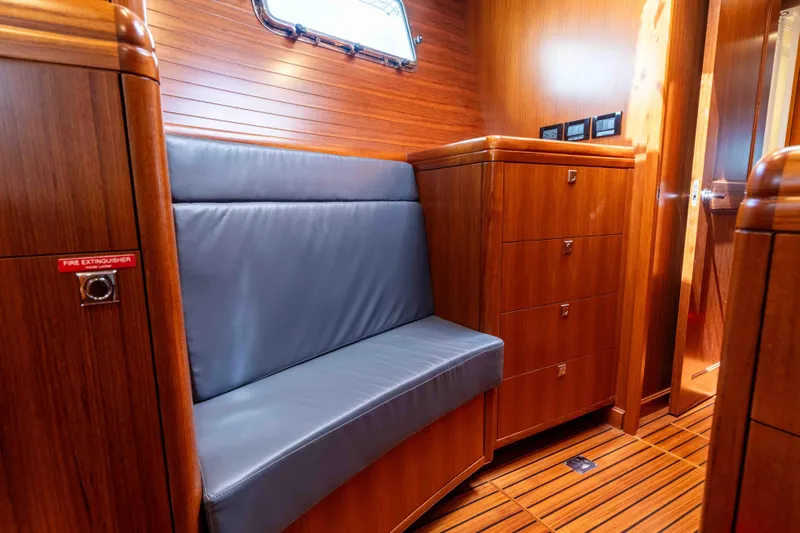 Martini Yacht Photos Pics Luxurious wooden interior of 2022 Nordhavn N63 yacht with cushioned seating and storage.