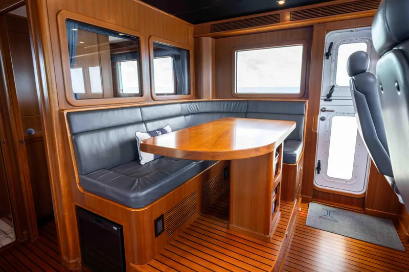 Martini Yacht Photos Pics Luxurious 2022 Nordhavn N63 yacht interior with wooden dining area and leather seating.