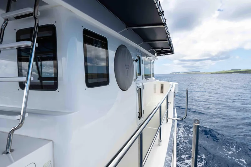 Martini Yacht Photos Pics 2022 Nordhavn N63 yacht cruising on open sea with clear skies.