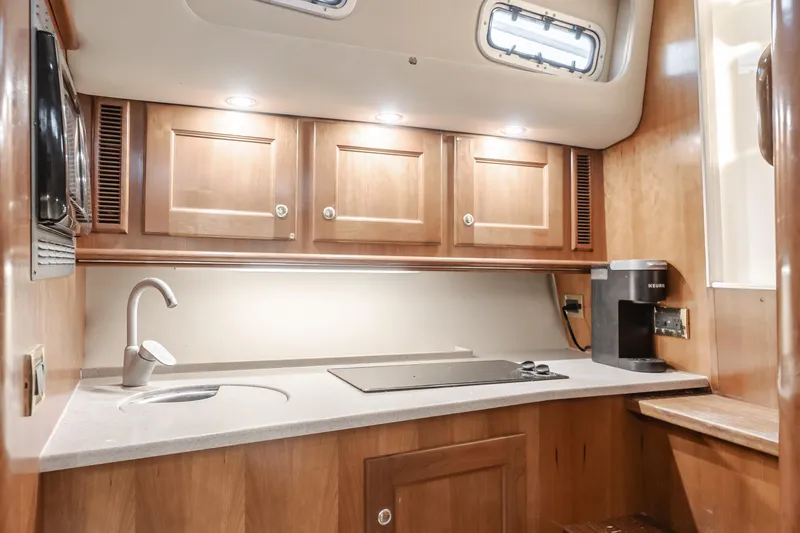 Pez Finder Yacht Photos Pics Luxurious 2006 Rampage 38 Express yacht kitchen with wooden cabinets and modern appliances.