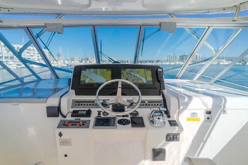 Pez Finder Yacht Photos Pics 2006 Rampage 38 Express helm with navigation screens and controls, overlooking marina.