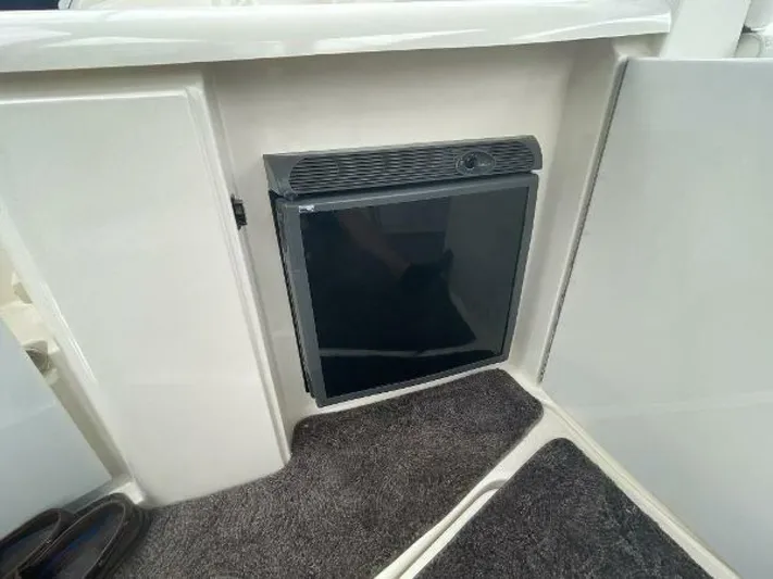  Yacht Photos Pics 2006 Cruisers Yachts 340 Express interior with compact refrigerator and carpeted flooring.