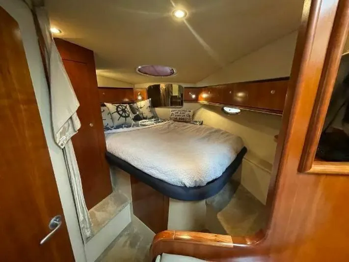  Yacht Photos Pics Luxurious cabin interior of 2006 Cruisers Yachts 340 Express with cozy bed and wooden finishes.