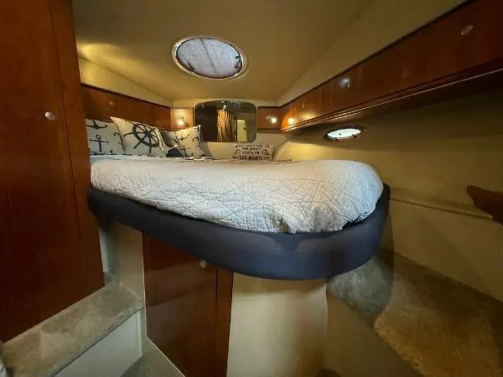  Yacht Photos Pics 2006 Cruisers Yachts 340 Express cabin with cozy bed and nautical-themed decor.