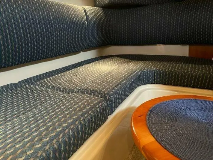  Yacht Photos Pics 2006 Cruisers Yachts 340 Express interior seating with blue patterned upholstery and wooden table.