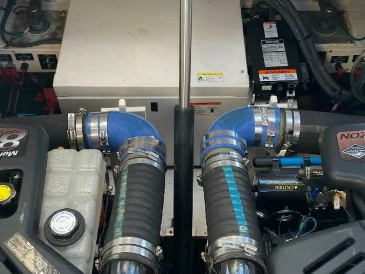  Yacht Photos Pics Engine compartment of a 2006 Cruisers Yachts 340 Express, featuring dual blue hoses and mechanical components.