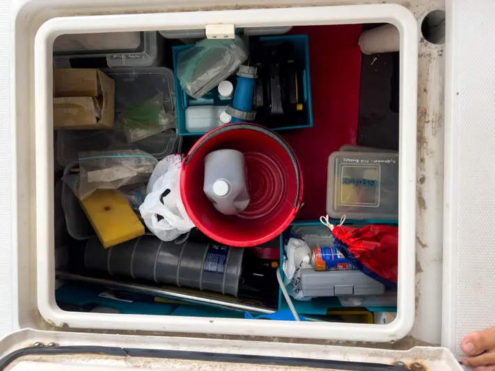 Whatabout Yacht Photos Pics Storage compartment on 2005 Antares PDQ 44 boat, filled with various supplies and tools.