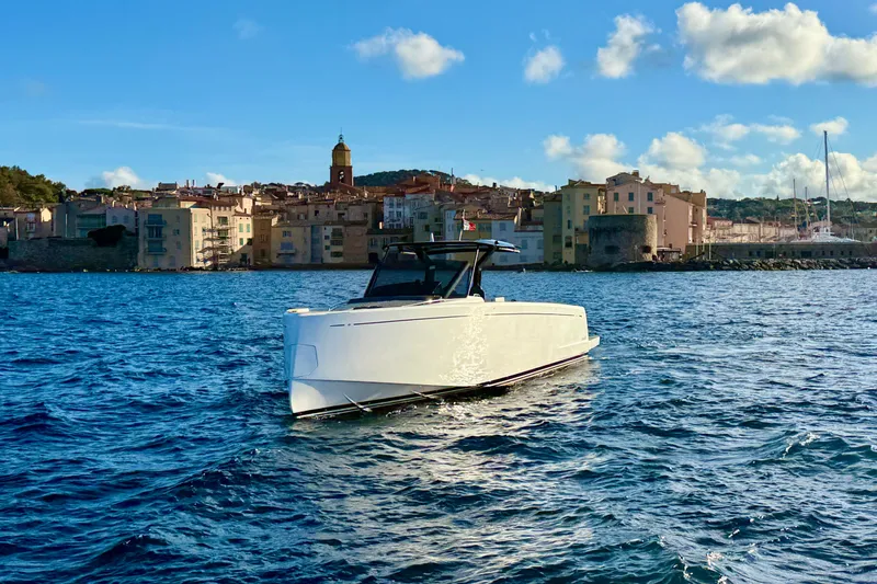 King Mouss Yacht Photos Pics 2020 Pardo Yachts 43 cruising near a picturesque coastal town under a clear blue sky.