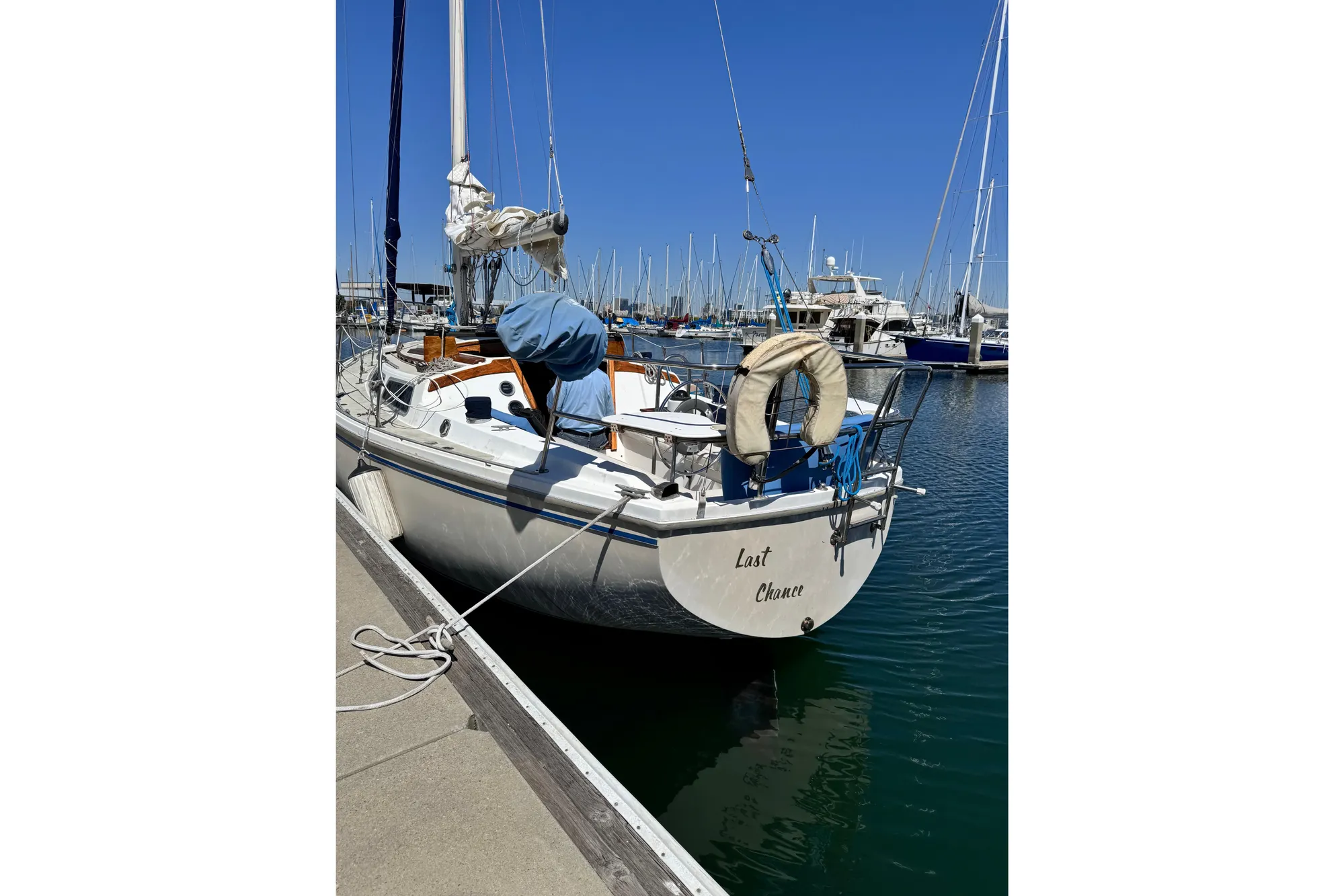 1980 Catalina 30 sailboat docked in marina under clear blue sky.