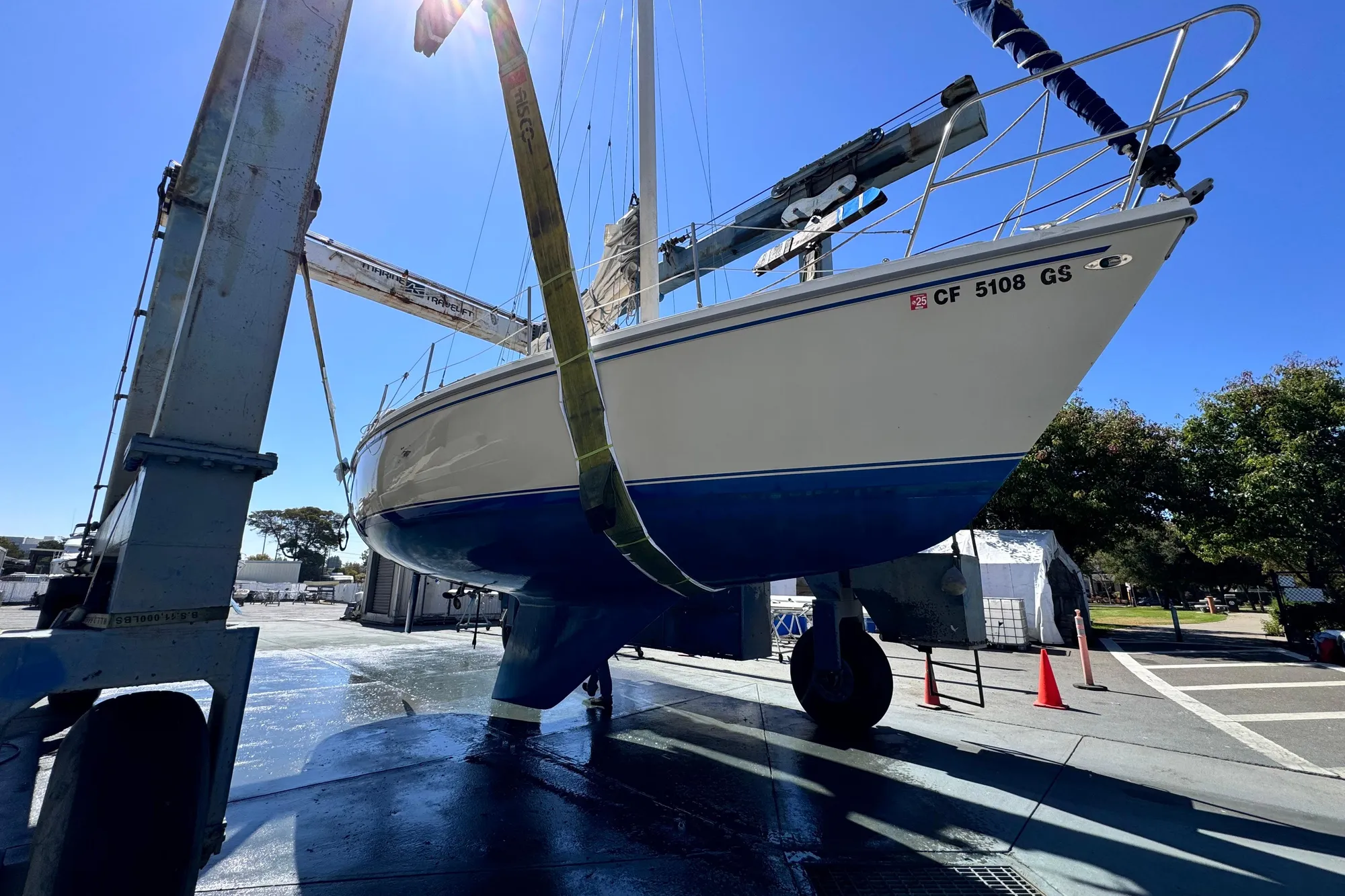 1980 Catalina 30 sailboat in dry dock, undergoing maintenance under clear blue sky.