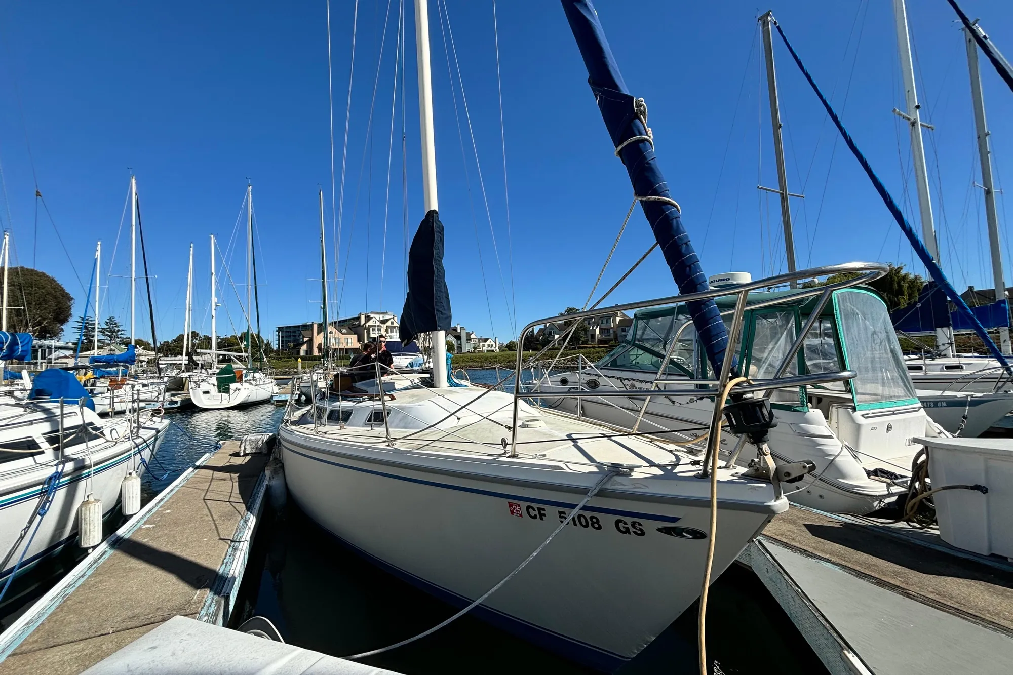 1980 Catalina 30 sailboat docked at marina under clear blue sky.
