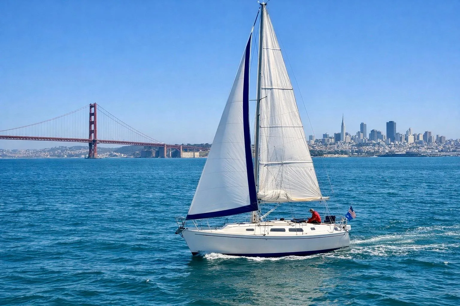 1980 Catalina 30 sailboat cruising near Golden Gate Bridge, San Francisco skyline in background.