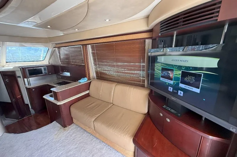  Yacht Photos Pics Luxurious interior of 2005 Sea Ray 500 Sedan Bridge with sofa, TV, and kitchenette.