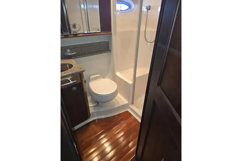  Yacht Photos Pics 2005 Sea Ray 500 Sedan Bridge bathroom with shower, toilet, and wooden flooring.