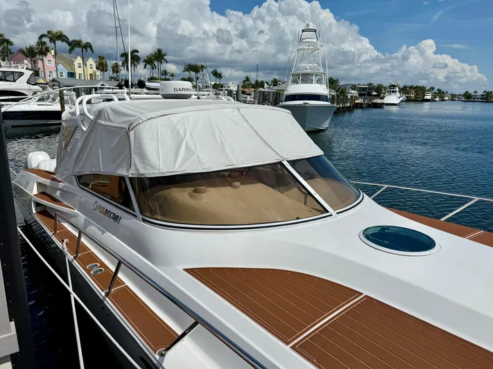  Yacht Photos Pics 2005 Fountain 48 Express Cruiser docked at marina, clear skies, palm trees in background.