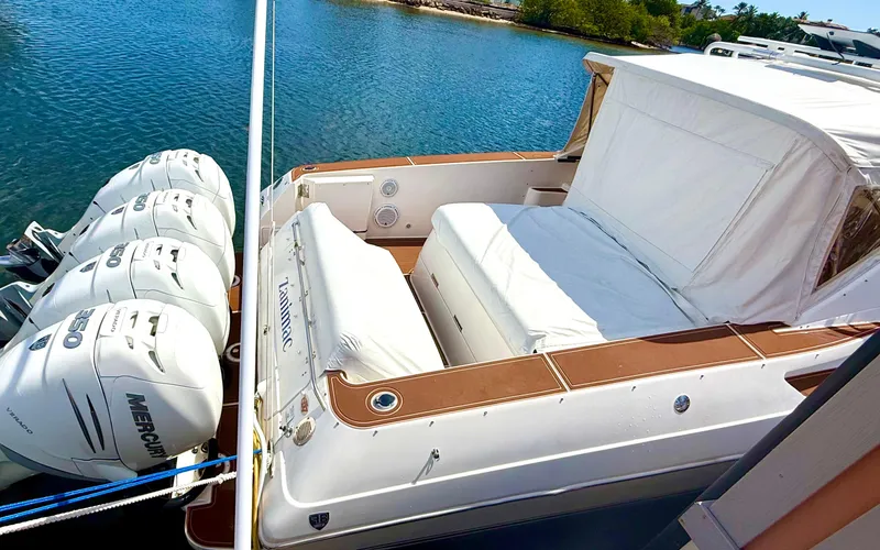  Yacht Photos Pics 2005 Fountain 48 Express Cruiser with triple Mercury engines docked by the water.