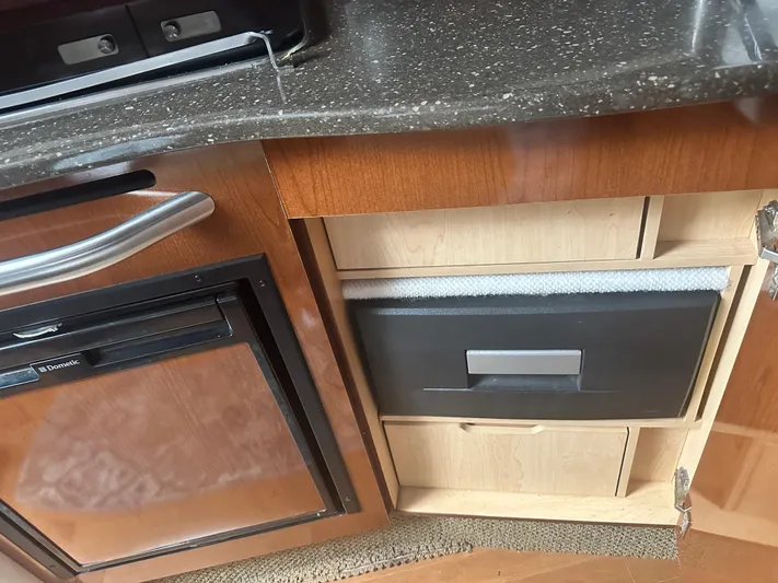  Yacht Photos Pics Kitchen area of 2012 Sea Ray 330 Sundancer with wooden cabinetry and compact fridge.