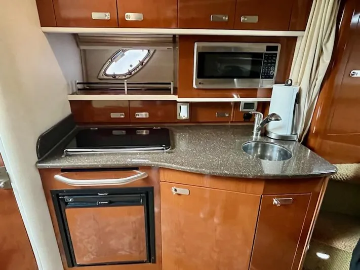  Yacht Photos Pics Kitchen area of 2012 Sea Ray 330 Sundancer with microwave, sink, and compact fridge.