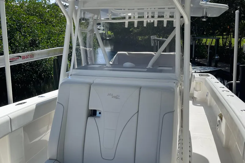  Yacht Photos Pics 2022 SeaVee 370z boat interior with seating and console, docked near lush greenery.