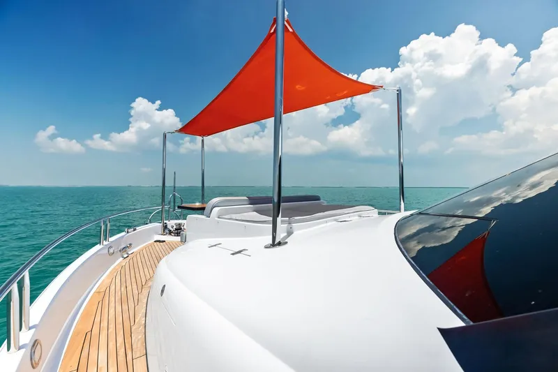 Voyager Yacht Photos Pics 2006 Lazzara Skylounge yacht deck with red canopy, ocean view, and clear blue sky.