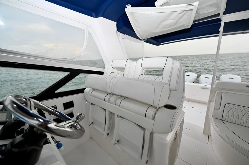 Yacht Photos Pics 2021 Intrepid 438 Evolution boat interior with white seating and blue canopy.