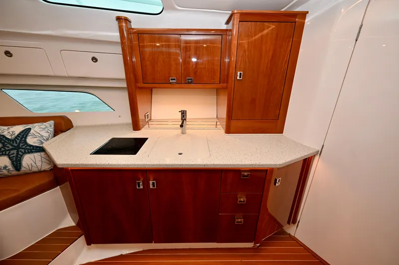  Yacht Photos Pics Luxurious 2021 Intrepid 438 Evolution yacht interior with elegant wood cabinetry and modern kitchenette.