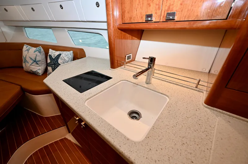  Yacht Photos Pics Luxurious 2021 Intrepid 438 Evolution yacht interior with modern kitchen and seating area.