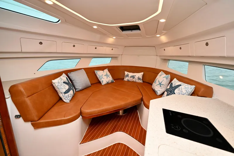  Yacht Photos Pics Luxurious interior of 2021 Intrepid 438 Evolution yacht with leather seating and decorative pillows.