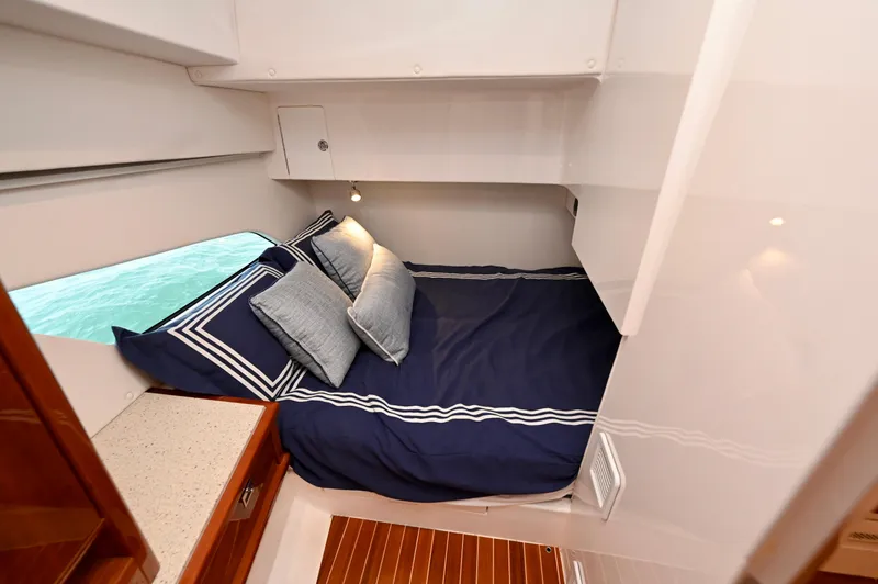  Yacht Photos Pics Cozy cabin interior of 2021 Intrepid 438 Evolution yacht with blue bedding.