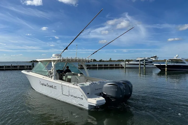  Yacht Photos Pics 2023 Sailfish 316 DC boat on water, clear sky, docked yachts in background.