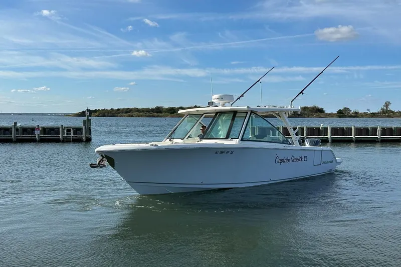  Yacht Photos Pics 2023 Sailfish 316 DC boat on water near dock under blue sky.