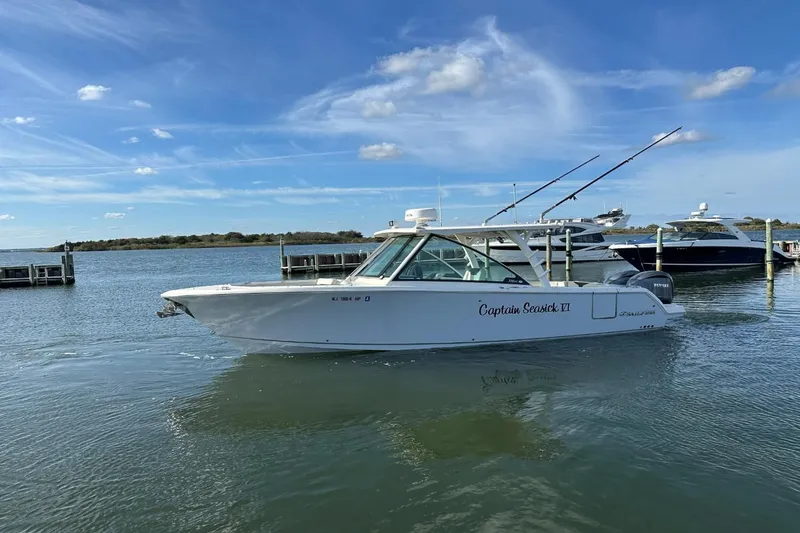 Yacht Photos Pics 2023 Sailfish 316 DC boat docked on calm water under a clear blue sky.