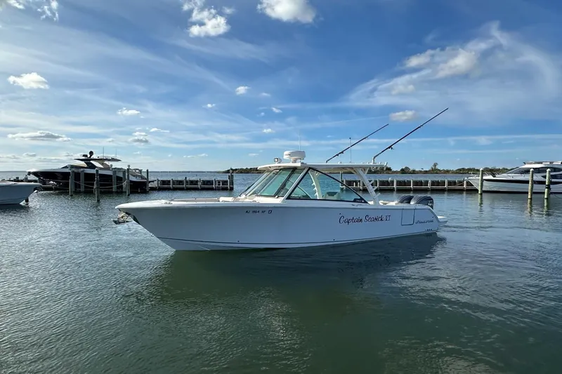  Yacht Photos Pics 2023 Sailfish 316 DC boat docked in a marina under a clear blue sky.