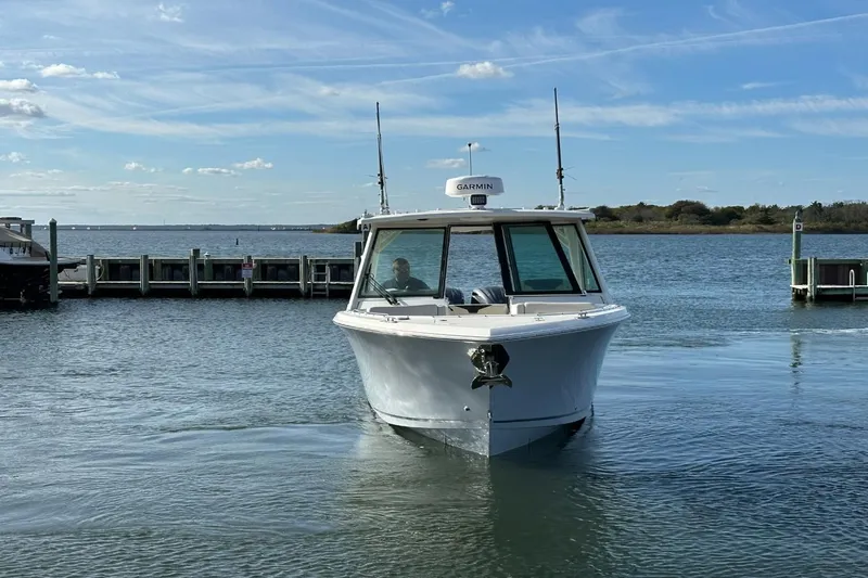  Yacht Photos Pics 2023 Sailfish 316 DC boat on water near a dock under a clear sky.