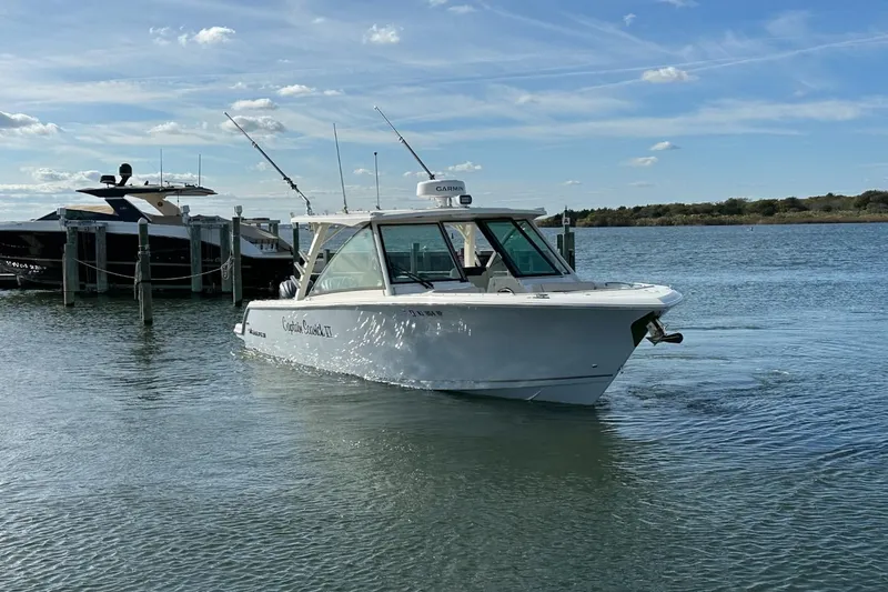  Yacht Photos Pics 2023 Sailfish 316 DC boat cruising on a calm lake near a dock.