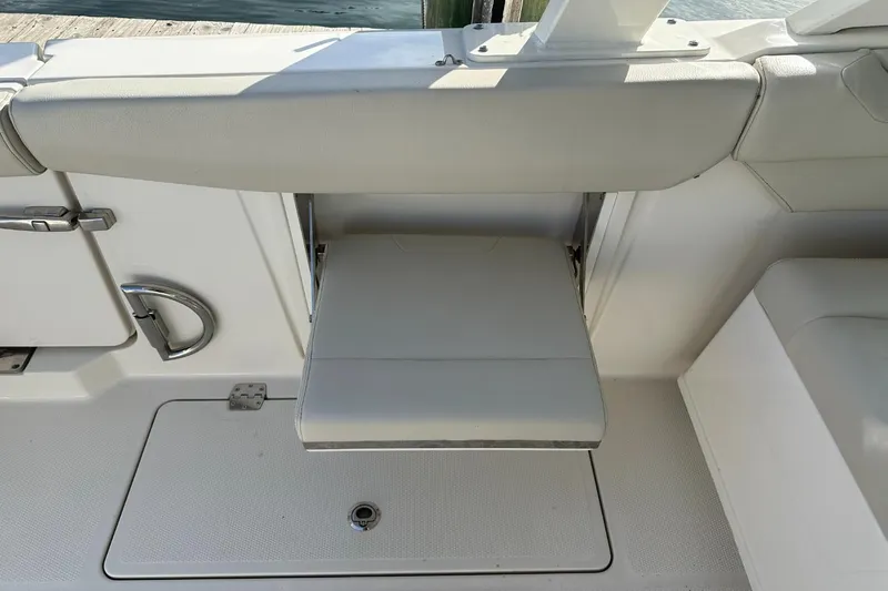  Yacht Photos Pics 2023 Sailfish 316 DC boat interior with foldable seat and storage compartment.