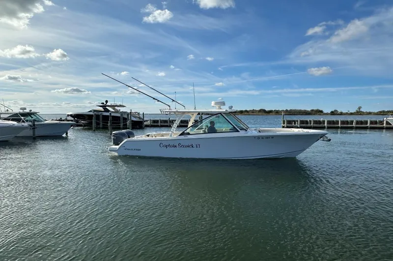  Yacht Photos Pics 2023 Sailfish 316 DC boat docked on calm water under a clear blue sky.
