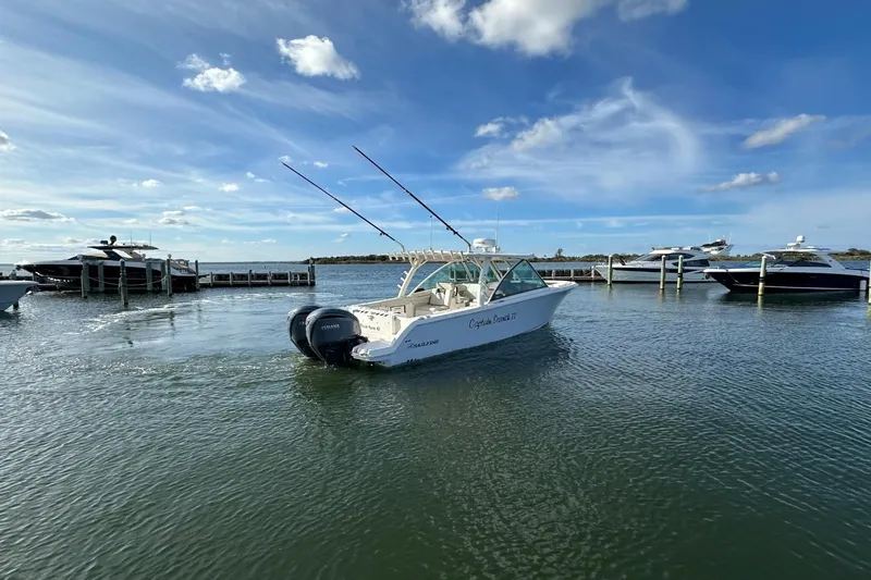  Yacht Photos Pics 2023 Sailfish 316 DC boat docked in a marina under a clear blue sky.
