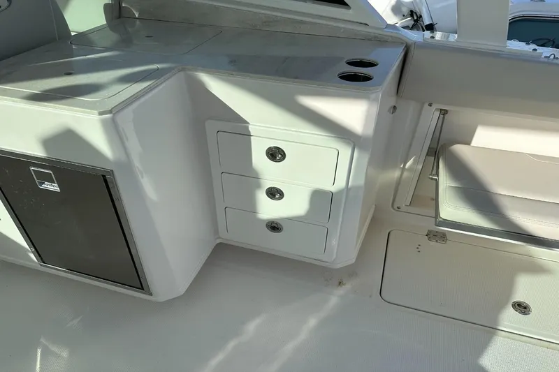  Yacht Photos Pics 2023 Sailfish 316 DC boat interior with storage drawers and a mini fridge.