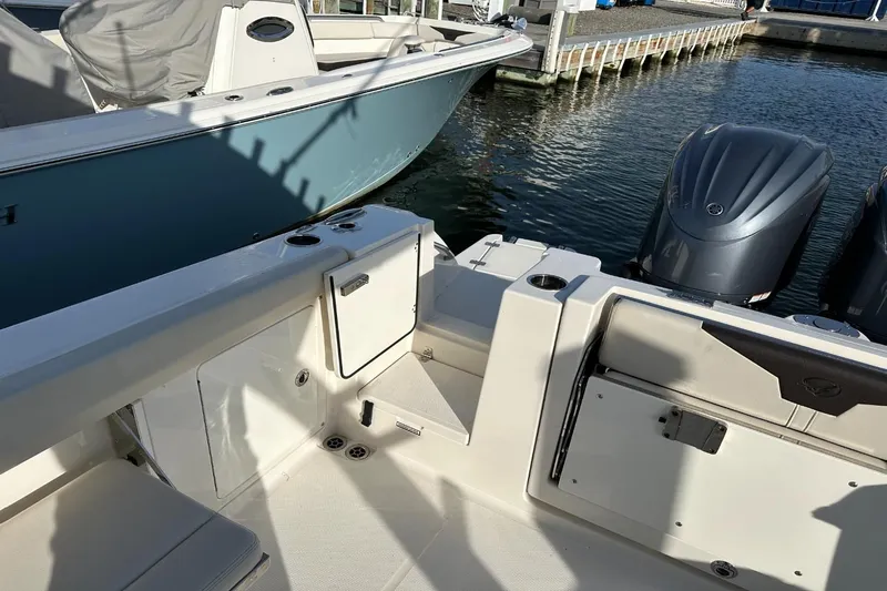  Yacht Photos Pics 2023 Sailfish 316 DC boat interior with dual outboard motors at a marina.